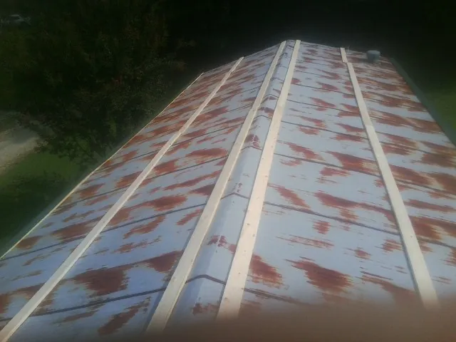 Rusted metal roof panels with new wood purlins before replacement — Storm Damage Roof Repair in Decatur by Roofing Brothers